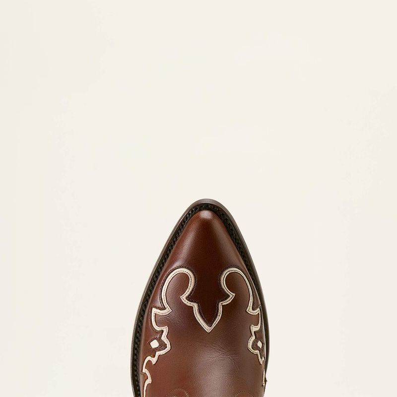 Brown cowboy boot with decorative white patterns on a beige background