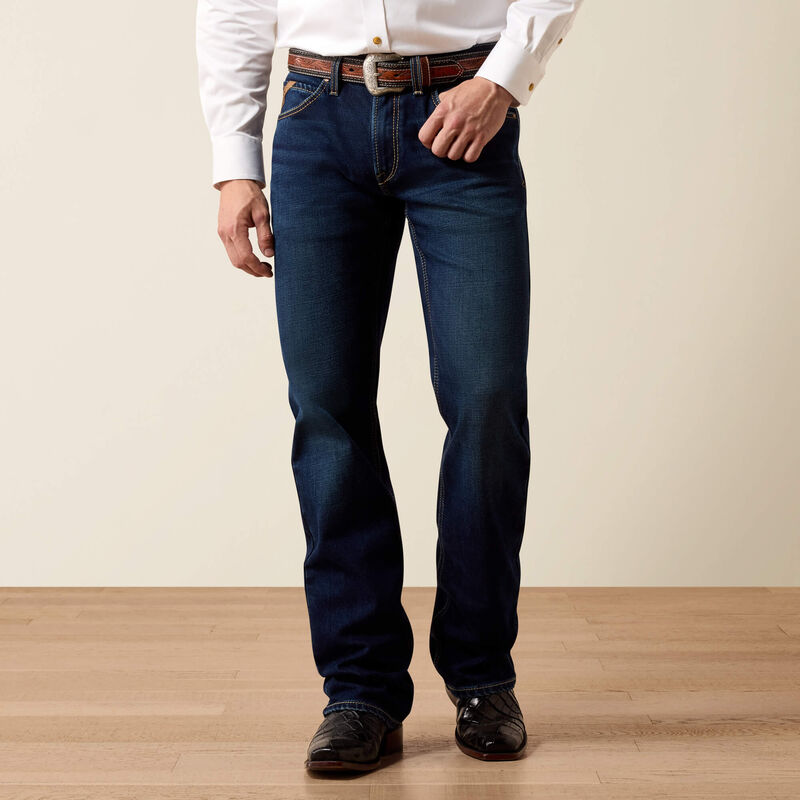 Person wearing blue jeans and a white shirt on a plain background