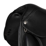 Close-up of a black leather saddle with a button on a white background